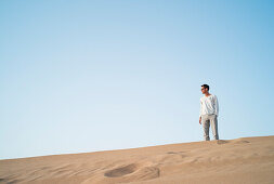 Man on dune in a desert, Dubai, United Arab Emirates