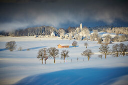 Blick auf Holzhausen mit Pfarrkirche St. Johann Baptist im Winter, Holzhausen, Münsing, Oberbayern, Bayern, Deutschland