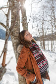 Young woman leaning against a tree, Spitzingsee, Upper Bavaria, Germany