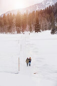 Zwei junge Frauen spazieren im Schnee, Spitzingsee, Oberbayern, Bayern, Deutschland