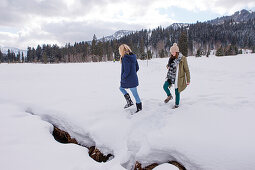 Two young women in snow, Spitzingsee, Upper Bavaria, Germany