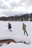 Zwei junge Frauen im Schnee, Spitzingsee, Oberbayern, Bayern, Deutschland