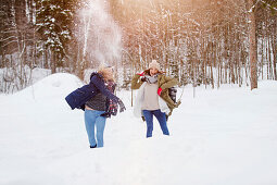Two young women throwing snowballs, Spitzingsee, Upper Bavaria, Germany