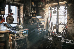 warm light shining through the window of a chaotic blacksmiths workshop, Vellberg, Schwaebisch Hall, Baden-Wuerttemberg, Germany