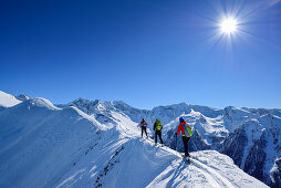 Drei Personen auf Skitour gehen über Schneegrat, Zillertaler Alpen im Hintergrund, Gammerspitze, Schmirntal, Zillertaler Alpen, Tirol, Österreich