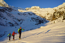 Three persons back-country skiing ascending towards Schneespitze, Schneespitze, valley of Pflersch, Stubai Alps, South Tyrol, Italy