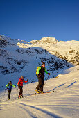 Three persons back-country skiing ascending towards Schneespitze, Schneespitze, valley of Pflersch, Stubai Alps, South Tyrol, Italy