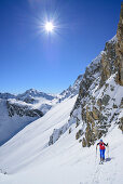 Frau auf Skitour steigt zur La Forcellina auf, Monte Viraysse im Hintergrund, Col Sautron, Valle Maira, Cottische Alpen, Piemont, Italien