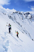 Two persons back-country skiing ascending towards Piz Sursass, Piz Nuna in the background, Piz Sursass, Sesvenna Alps, Engadin, Grisons, Switzerland