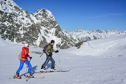 Two persons back-country skiing ascending towards Piz Lischana, Piz Lischana, Sesvenna Alps, Engadin, Grisons, Switzerland