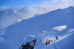 Group of persons back-country skiing having a break, Pallspitze, Langer Grund, Kitzbuehel range, Tyrol, Austria