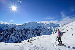 Woman back-country skiing looking at Kitzbuehel range, Floch, valley of Spertental, Kitzbuehel range, Tyrol, Austria