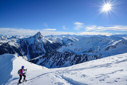 Woman back-country skiing asending towards Floch, Grosser Rettenstein in background, Floch, valley of Spertental, Kitzbuehel range, Tyrol, Austria