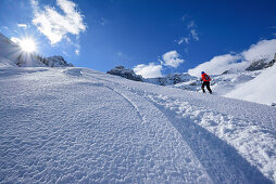 Woman back-country skiing ascending towards Monte Soubeyran, Monte Soubeyran, Valle Maira, Cottian Alps, Piedmont, Italy