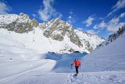 Woman back-country skiing ascending towards Monte Soubeyran, Monte Soubeyran, Valle Maira, Cottian Alps, Piedmont, Italy