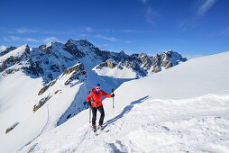 Frau auf Skitour steigt zum Monte Soubeyran auf, im Hintergrund Monte Vallonasso und Monte Sautron, Monte Soubeyran, Valle Maira, Cottische Alpen, Piemont, Italien