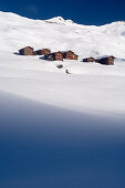Die Holzhäuser des Weilers Meierhof mitten in der verschneiten Landschaft des Hochtals namens Fondei, Bündner Alpen, Kanton Graubünden, Schweiz
