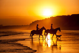 Zwei junge Frauen reiten am Strand entlang, Algarve, Portugal