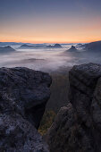 Blick vom Gleitmannshorn über den kleinen Zschand mit Nebel im Morgengrauen mit Felsen im Vordergrund, Kleiner Winterberg, Nationalpark Sächsische Schweiz, Sachsen, Deutschland