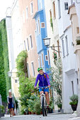 Fahrradfahrerin fährt durch Altstadt, Burghausen, Chiemgau, Bayern, Deutschland