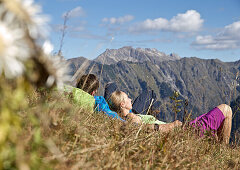 Couple having a break from hiking on a sunny day, Oberstdorf, Bavaria, Germany