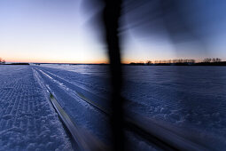 Young woman cross-country skiing at sunset, Allgaeu, Bavaria, Germany