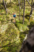 young woman running in a moorland forest, Berg at Lake Starnberg, Upper Bavaria, Germany