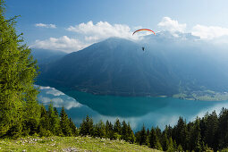 Paraglider starting off from Zwoelferkopf above Lake Achensee, overlooking Rofan mountains, Pertisau, Tirol, Austria