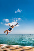 Junge springt von einem Steg, Südstrand, Burgtiefe, Fehmarn, Ostsee, Schleswig-Holstein, Deutschland