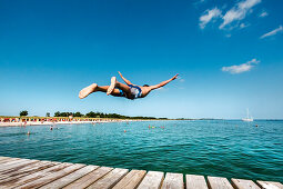 Boy diving from a pier, South beach, Burgtiefe, Fehmarn island, Baltic Coast, Schleswig-Holstein, Germany
