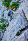 Frau klettert an Felswand, Selvaggio Blu, Nationalpark Golfo di Orosei e del Gennargentu, Sardinien, Italien