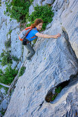 Woman climbing over rock face, Selvaggio Blu, National Park of the Bay of Orosei and Gennargentu, Sardinia, Italy