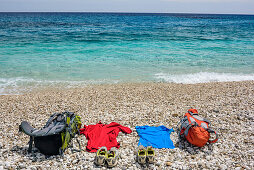 Rucksacks and clothes laying at beach of Cala Sisine at Mediterranean, Cala Sisine, Selvaggio Blu, National Park of the Bay of Orosei and Gennargentu, Sardinia, Italy