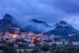 Illuminated village of Aggius with mountains, Aggius, Sardinia, Italy