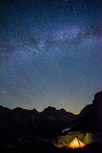 Illuminated tent in front of Lechtal Alps with starry sky, Lechtal Alps, Tyrol, Austria