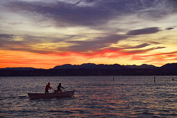 Boot, Fischerboot im Sonnenuntergang bei Sirmione mit Blick auf Desenzano del Garda, Lombardia, Italien, Europa