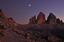 Sunset and moon over Paternkofel and Three Peaks (Drei Zinnen), scree and boulder field, Val Pusteria Valley, Sesto, Dolomites, South Tyrol, Veneto, Alto Adige, Three Peaks (Tre Cime di Lavaredo) Nature Park, UNESCO world heritage side, Italy, European Al