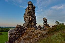 Young woman is hiking along rock formation Devil´s Wall (Teufelsmauer) at sunset, Neinstedt, Thale, Harz Foreland, Harz Mountains, Saxony-Anhalt, Germany