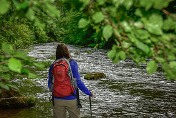 Junge Frau wandert am Fluß Bode im Bodetal auf dem Wanderweg Harzer Hexen Stieg von Thale nach Treseburg, Frühling, Harzvorland, Harz, Sachsen-Anhalt, Deutschland