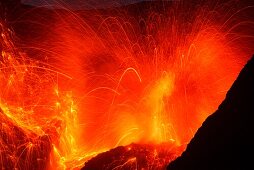 Close up of a huge eruption of Batu Tara volcano with lava bombs during the night, Indonesia, island of Komba, Flores Sea