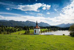 Hegratsrieder See, with traditional farmhouse and chapel, near Füssen, Bavaria, Germany