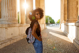 Young afro-american woman in backlight scenery at koenigsplatz, Munich, Bavaria, Germany