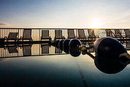 Pool mit Absperrleine und Liegestühlen im Hintergrund im Gegenlicht vom Sonnenaufgang, Daytona Beach, Florida, USA