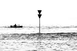 Silhouette, a canoeist passes a navigational sign on the Elbe, Hamburg, Germany