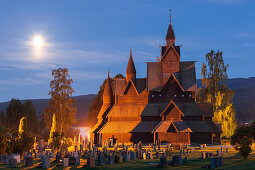 Stabkirche Heddal mit Grabsteinen in einer Sommernacht mit Vollmond, Notodden, Telemark, Norwegen, Skandinavien