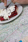 Person eating a delicious cake and looking at a map