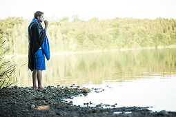 Junger Camper putzt sich die Zähne an einem See, Freilassing, Bayern, Deutschland