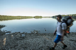 Junger Camper läuft an einem See, Freilassing, Bayern, Deutschland
