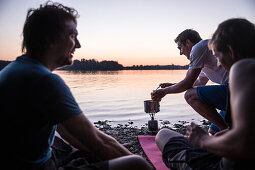 Three young men camping at a lake, Freilassing, Bavaria, Germany