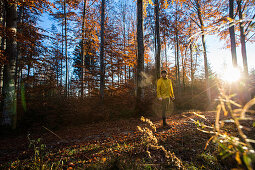 Junger Läufer steht auf einem Weg in einem Wald, Allgäu, Bayern, Deutschland